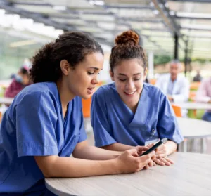 Nurses reviewing social media content on a mobile phone in a hospital setting